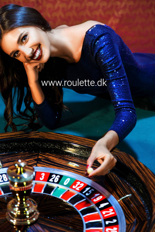 En kvindelig roulette dealer sætter spillet i gang med kuglen.