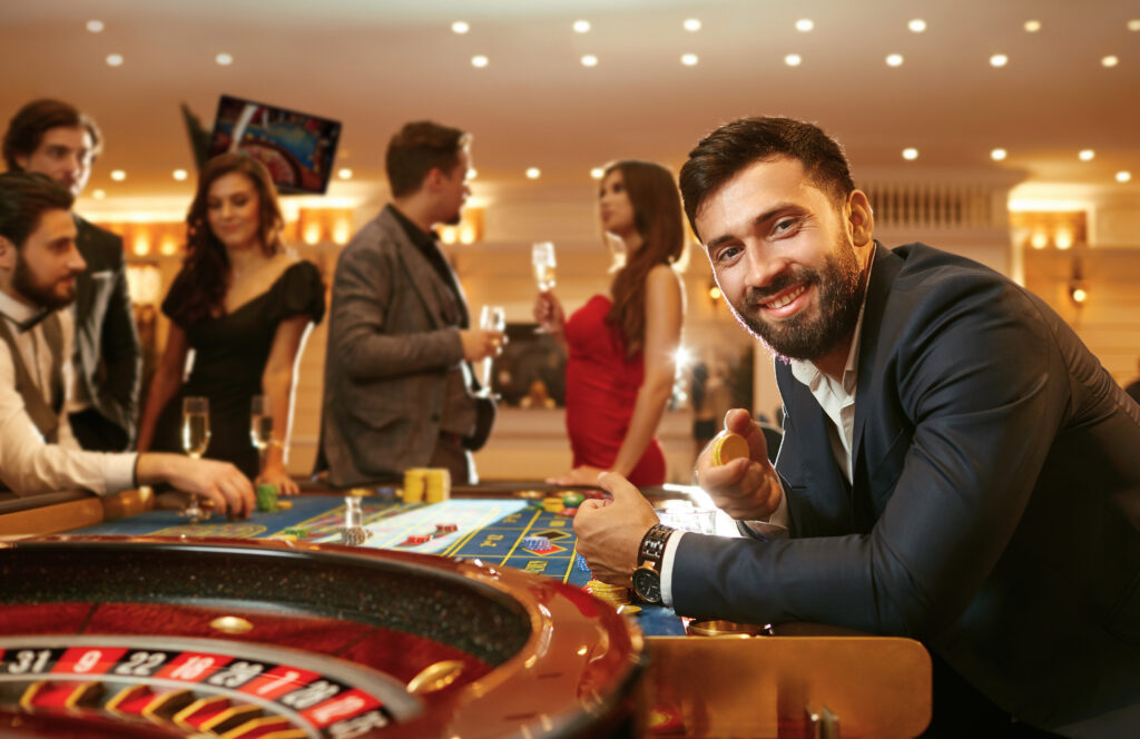 En mandlig casino gæst smiler til os fra roulette bordet.