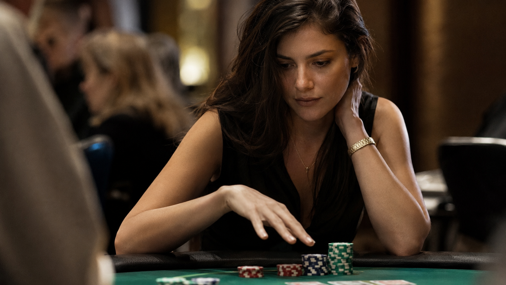 Ung kvindelig pokerspiller overvejer chips og kort ved et grønt pokerbord.